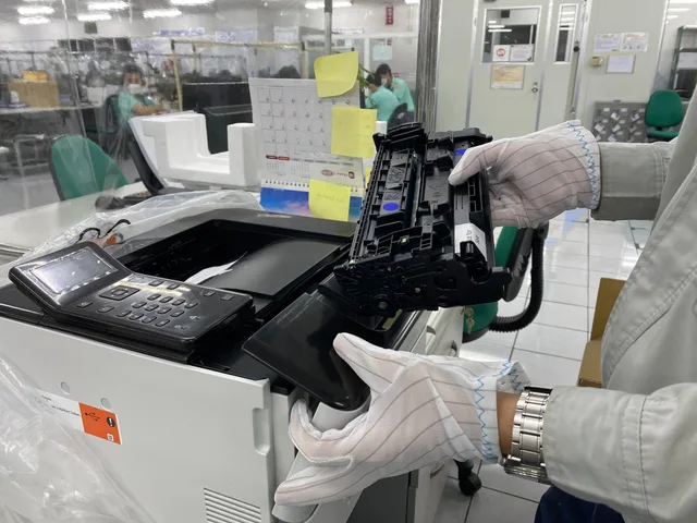 Worker replacing printer ink cartridge in a laboratory environment, highlighting technology maintenance. Placing, connecting, and testing a new home printer or scanner