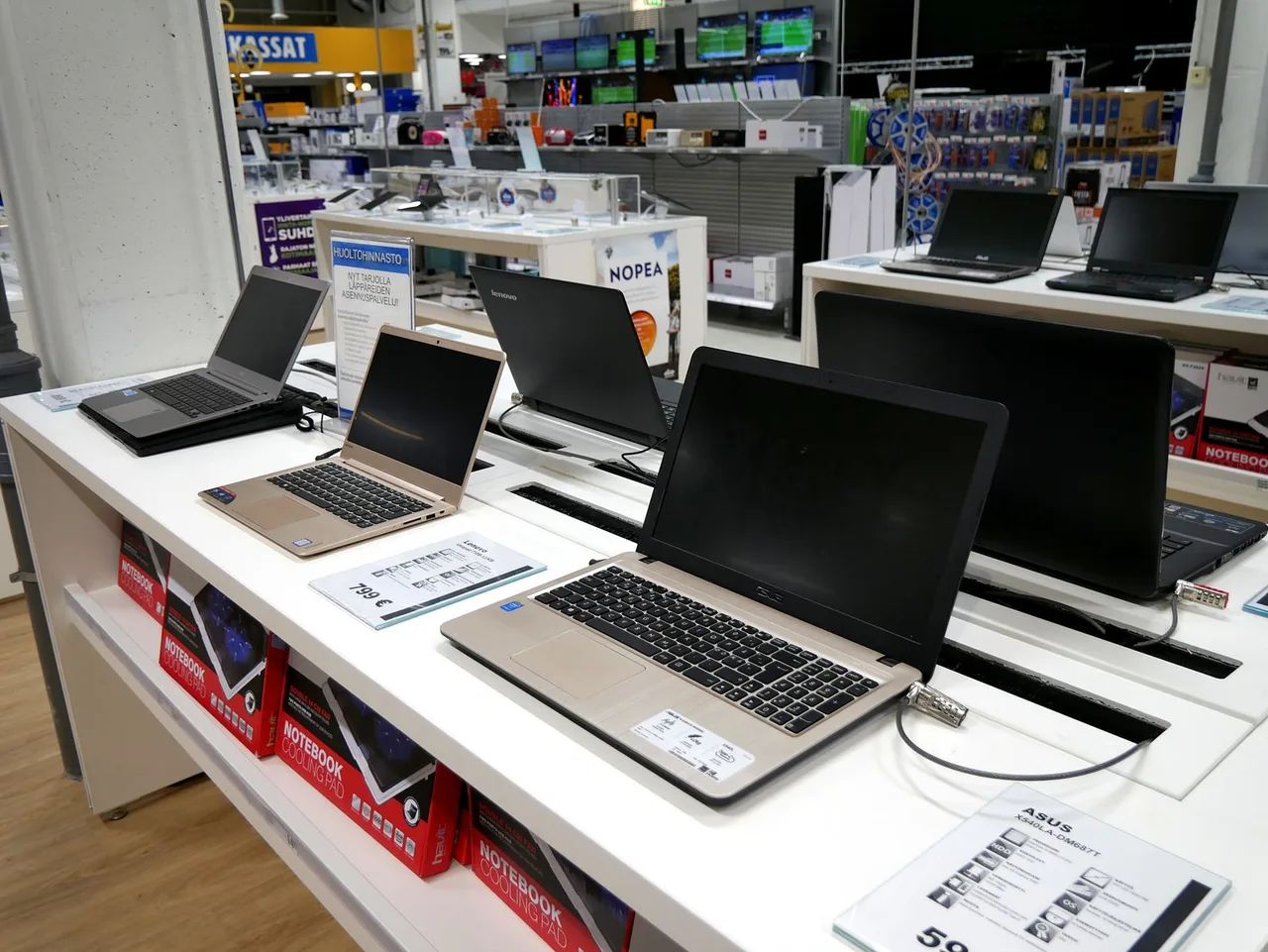 Several laptops displayed for sale in an electronics store