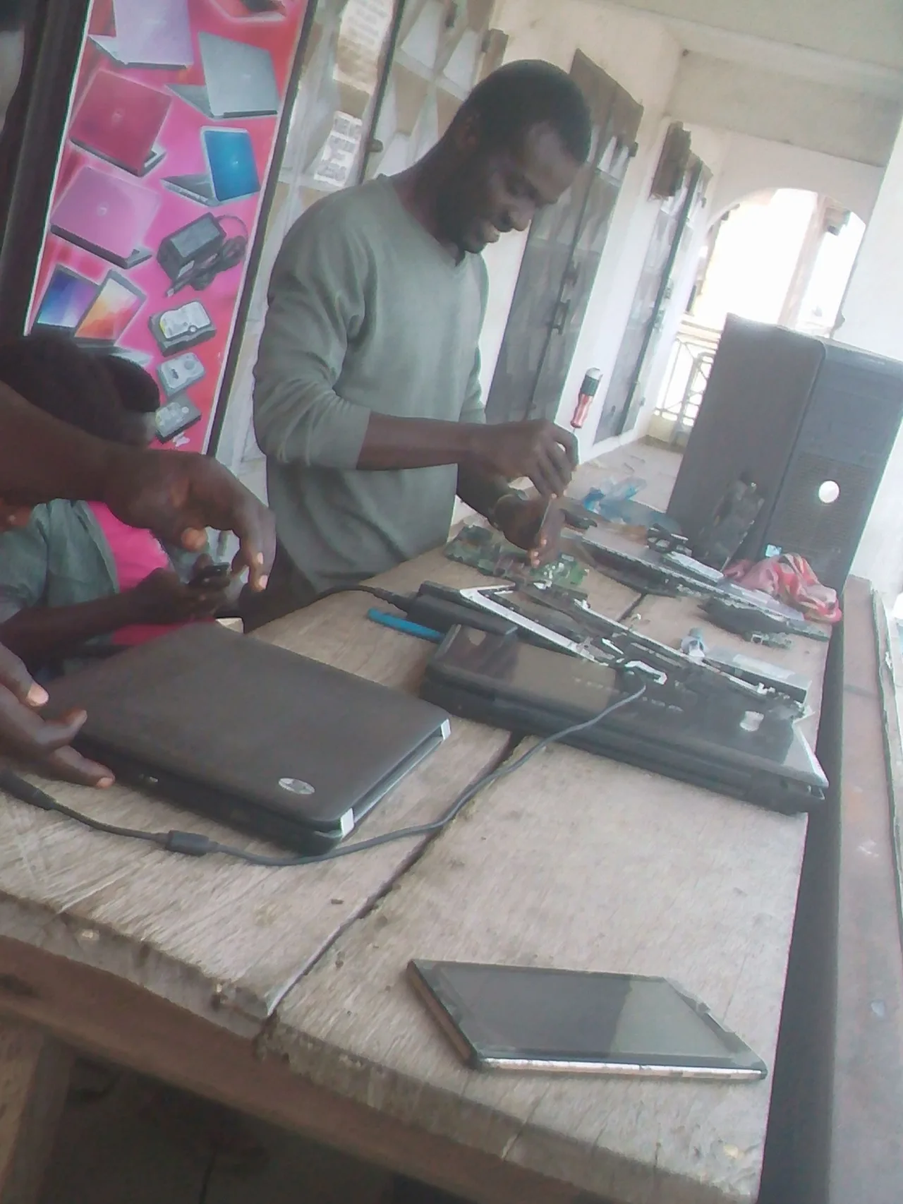 A laptop repairer working on an exposed laptop board