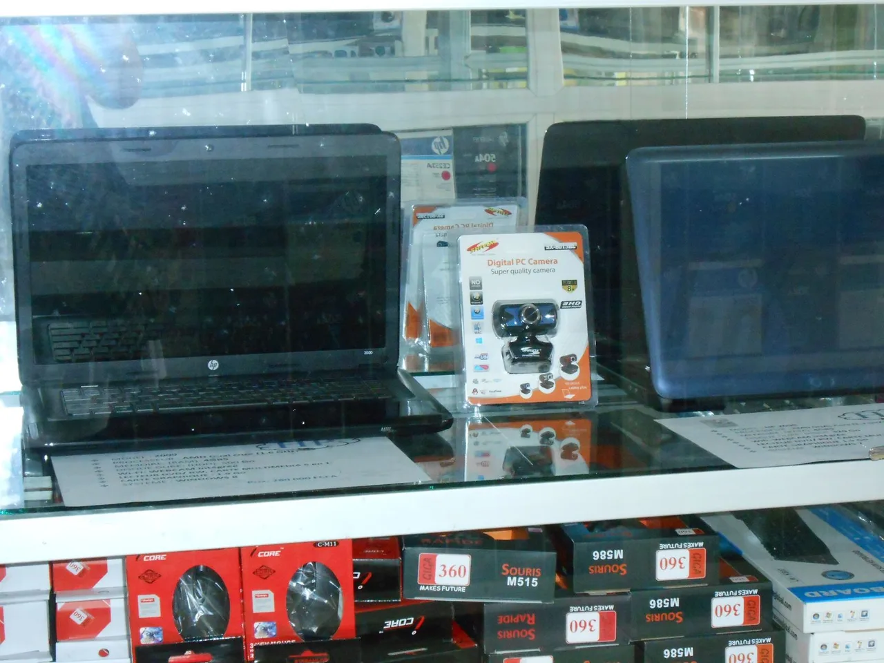Laptops, webcams, keyboards, and mice displayed in a computer shop